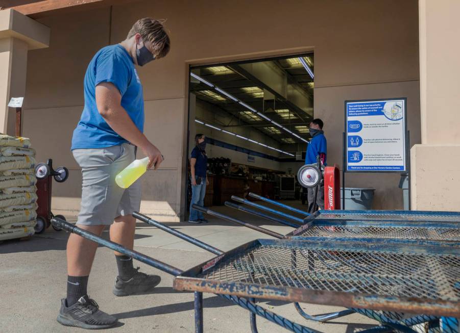 Recently hired Star Nursery employee Jason Joyce disinfects carts at the Star Nursery on W Trop ...