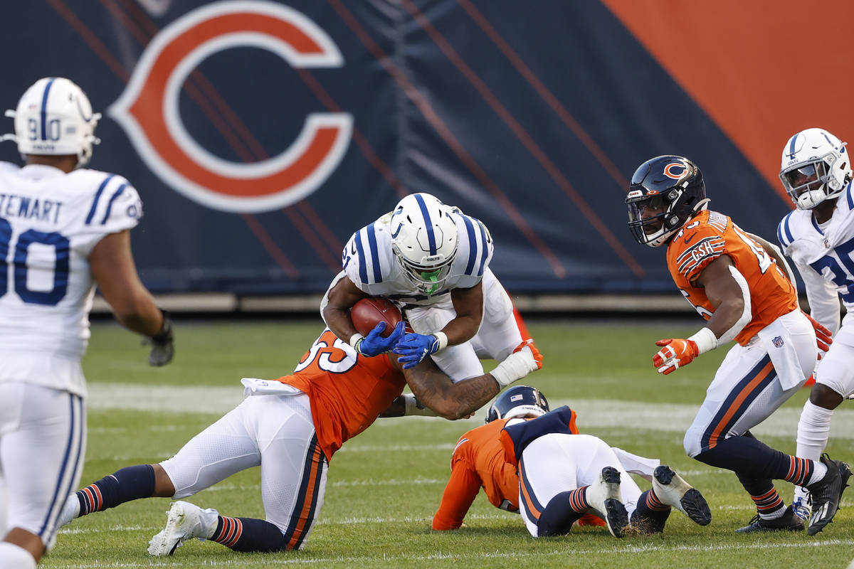 Indianapolis Colts running back Nyheim Hines (21) is tackled by Chicago Bears linebacker Josh W ...