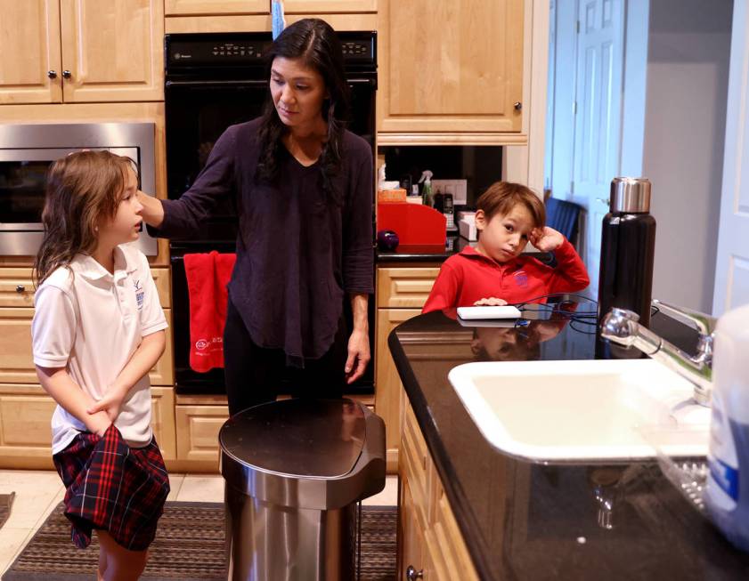 Prem Premsrirut gets her children Anya, 9, left, and Ivan, 7, ready for school at their Las Veg ...