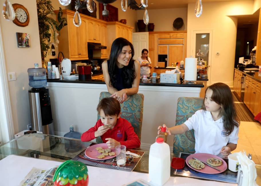 Prem Premsrirut gets her children Ivan, 7, left, and Anya, 9, ready for school at their Las Veg ...