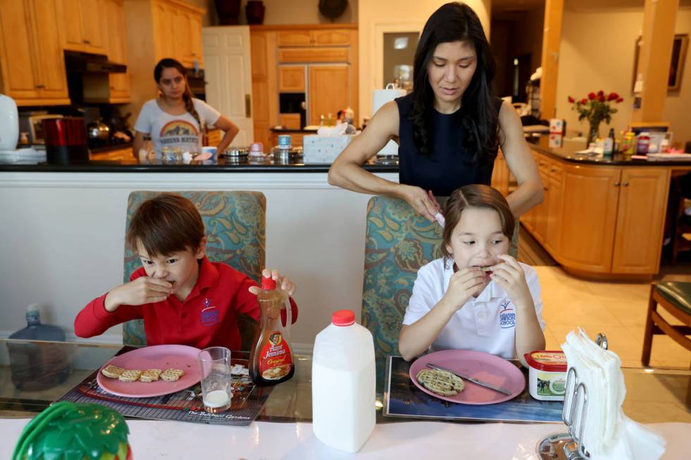 Prem Premsrirut gets her children Ivan, 7, left, and Anya, 9, ready for school at their Las Veg ...