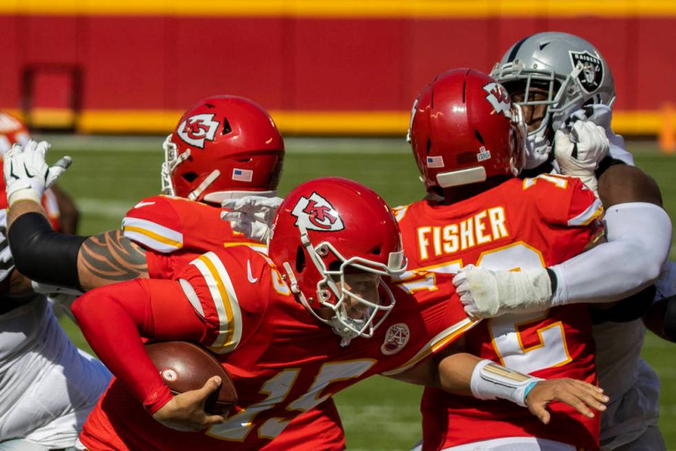 Kansas City Chiefs quarterback Patrick Mahomes (15) tries to scramble away from Las Vegas Raide ...