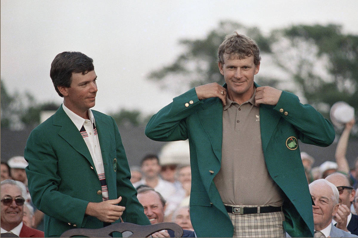 A smiling Sandy Lyle, right, is presented the Green Jacket of the Augusta National Golf Club af ...