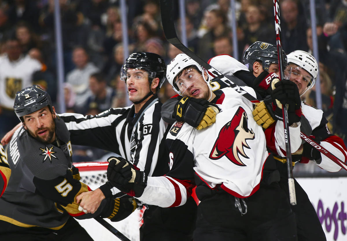 Arizona Coyotes' Ilya Lyubushkin gets tangled up in a scuffle alongside Golden Knights' Deryk E ...