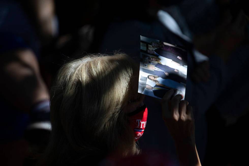 An audience member shades herself with a photo of the Trump family during an event featuring Iv ...