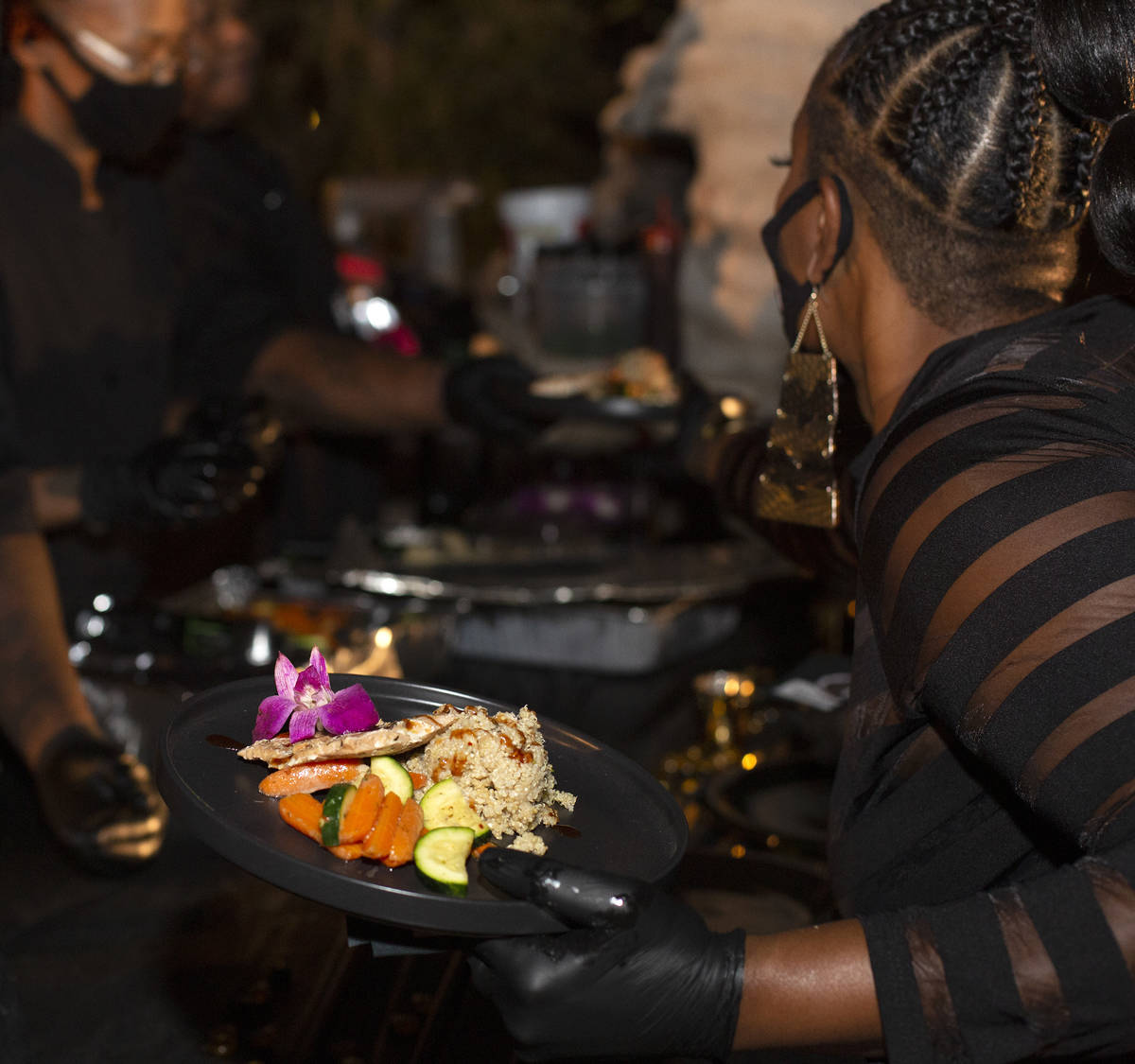 Emika Porter picks up plates to serve at a Noir Culinary Experience dinner to promote Black che ...