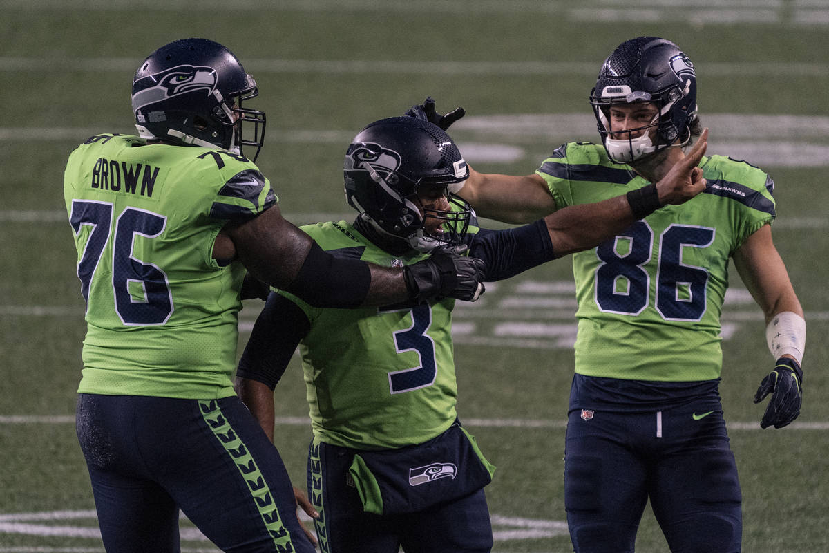 Seattle Seahawks quarterback Russell Wilson (3) is congratulated by teammates offensive lineman ...