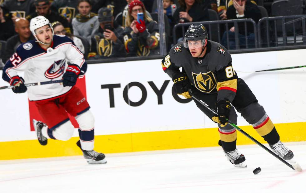 Golden Knights' Nate Schmidt (88) skates with the puck in front of Columbus Blue Jackets' Emil ...