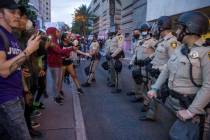 Las Vegas police look on as protesters confront them while marching along Casino Center Drive d ...