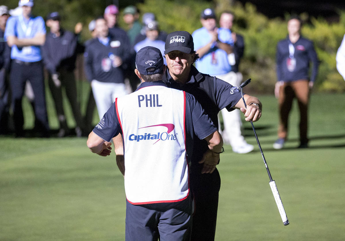 In this Nov. 23, 2018, file photo, Phil Mickelson hugs his caddie after defeating Tiger Woods i ...