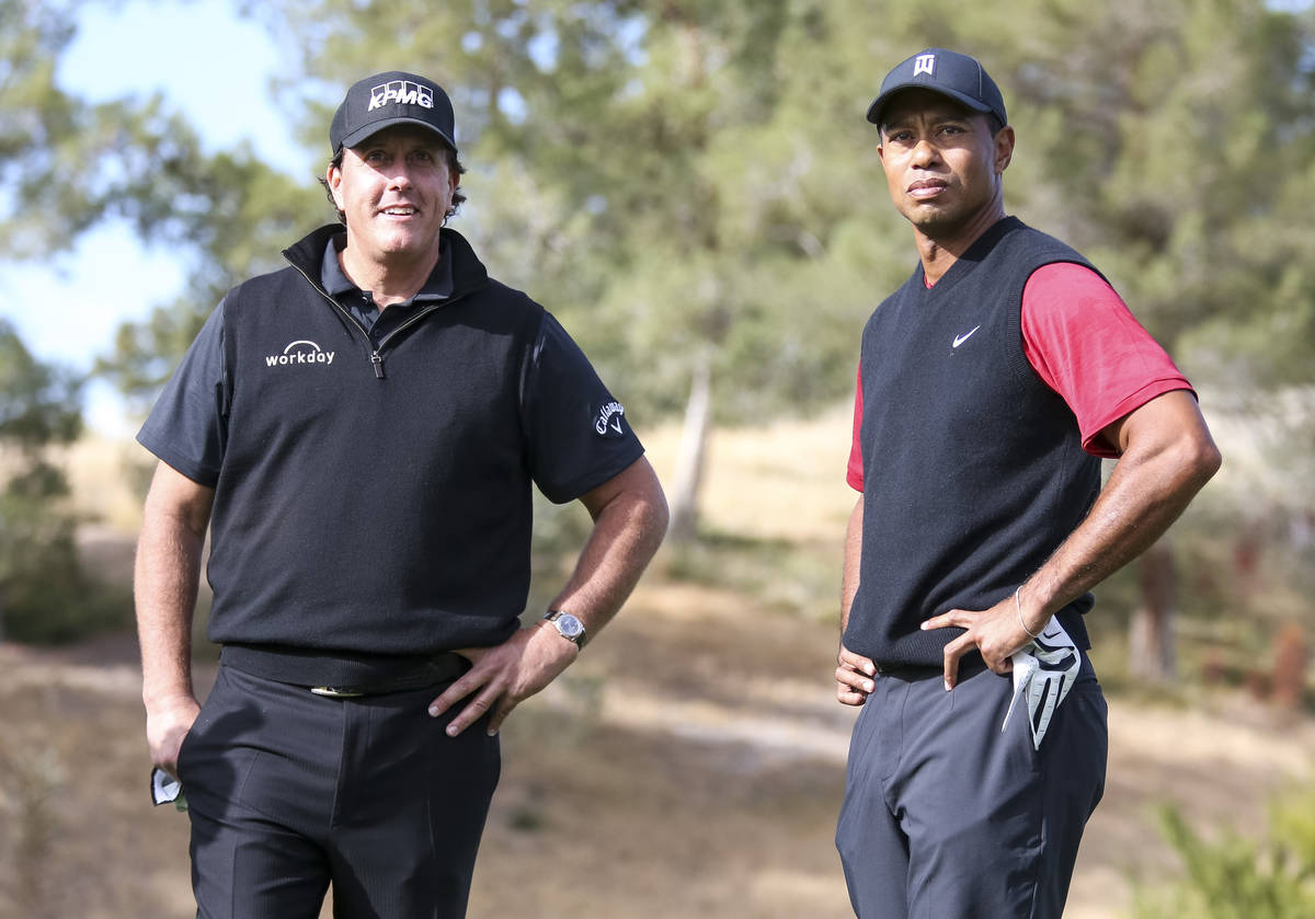 In this Nov. 23, 2018, file photo, Phil Mickelson, left, and Tiger Woods stand at the first tee ...