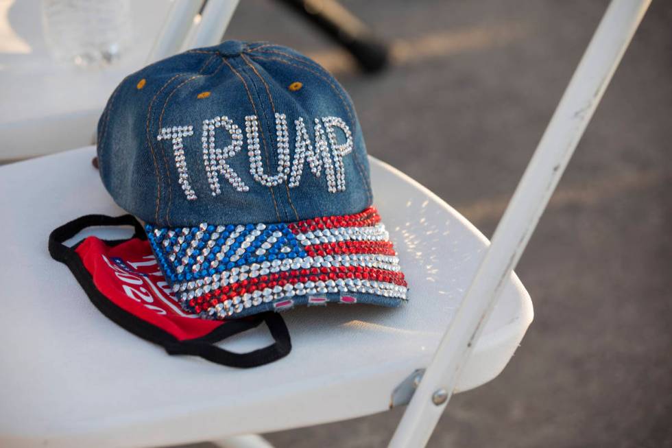 A hat and face mask acts as a seat holder at a campaign event for President Trump on Wednesday ...