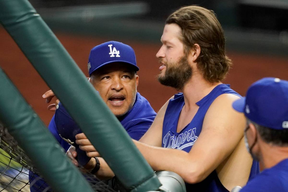 Los Angeles Dodgers manager Dave Roberts talks with starting pitcher Clayton Kershaw before Gam ...