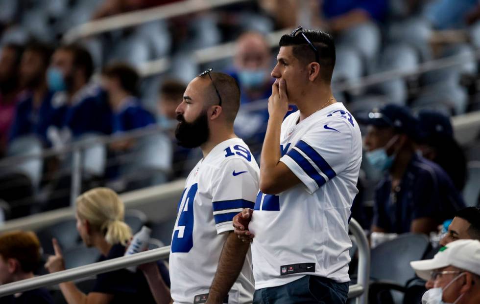 Dallas Cowboys fans look on as Dallas Cowboys quarterback Dak Prescott is carted off the field ...
