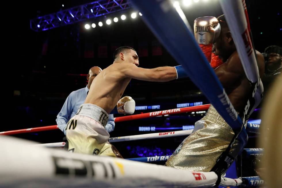Teofimo Lopez, left, punches Ghana's Richard Commey during the second round of an IBF lightweig ...
