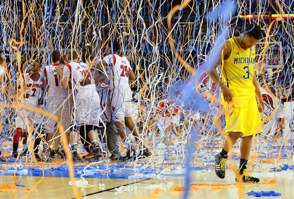 In this April 8, 2013, file photo, Michigan guard Trey Burke (3) walks off the court as confett ...