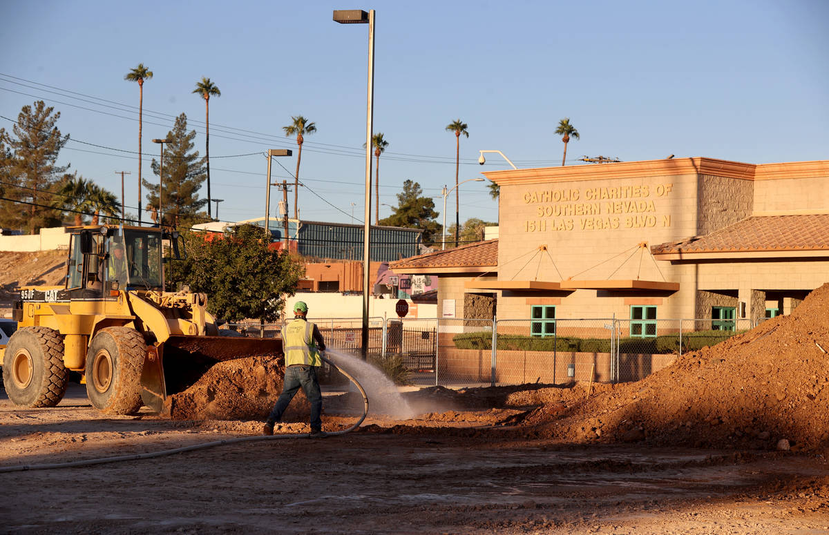 Workers remove dirt from a former landscaped area at Catholic Charities of Southern Nevada Frid ...