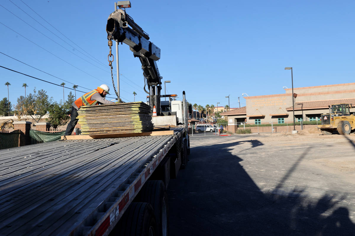 A worker unloads metal plates a former landscaped area at Catholic Charities of Southern Nevada ...