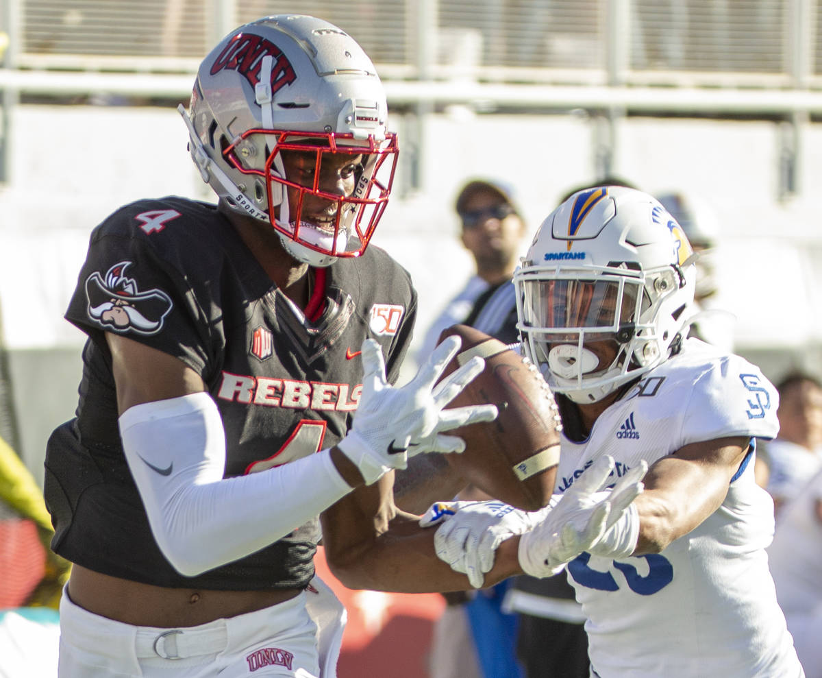 UNLV Rebels wide receiver Randal Grimes (4, left) eyes a long pass for a touchdown over the San ...