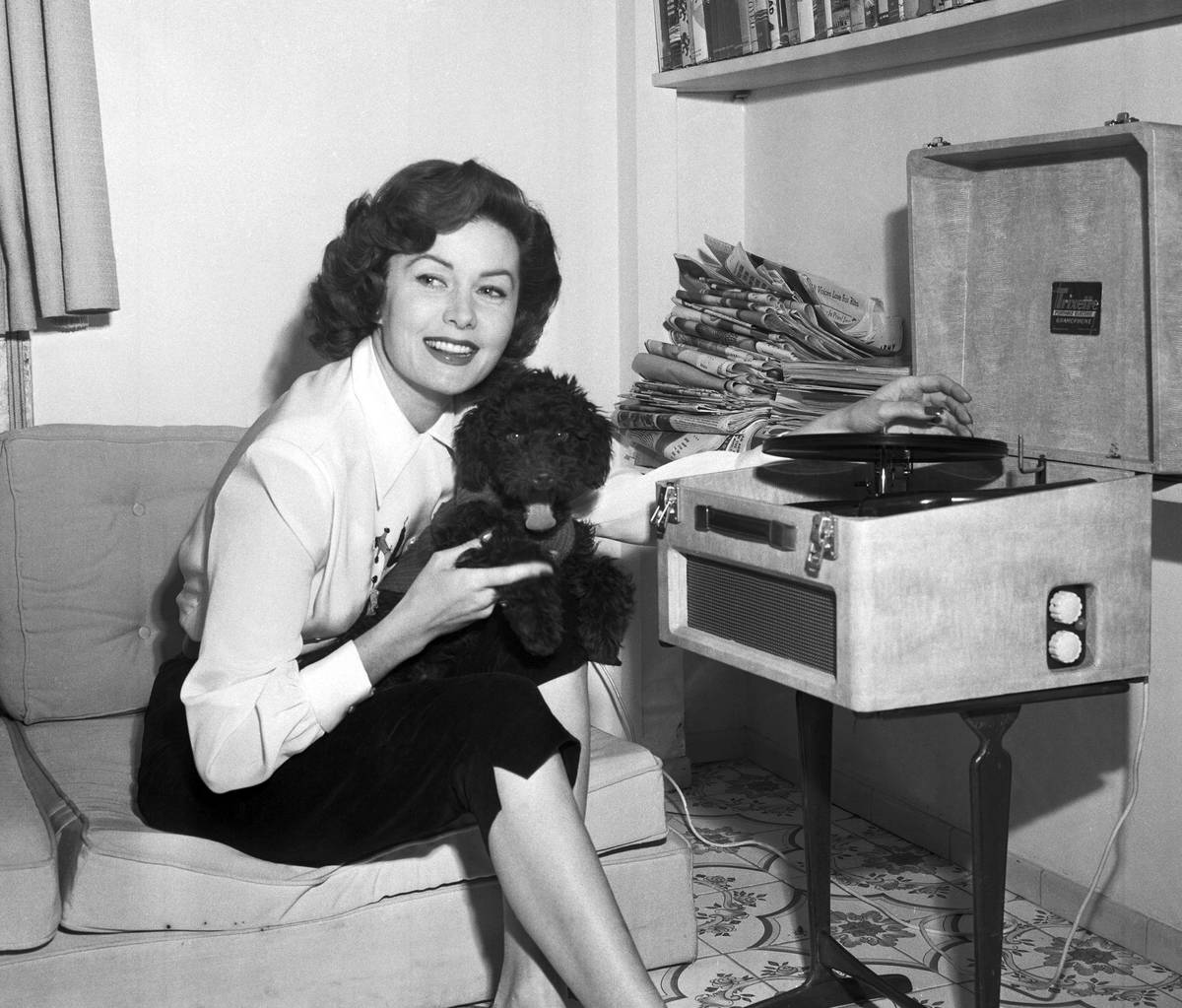 FILE - In this March 1, 1955 file photo, Actress Rhonda Fleming reads in her penthouse apartmen ...