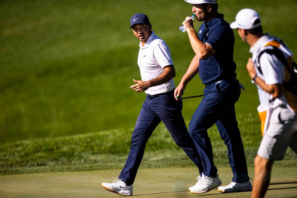Jason Day, left, talks with Jon Rahm as they walk toward the 13th green during the third round ...