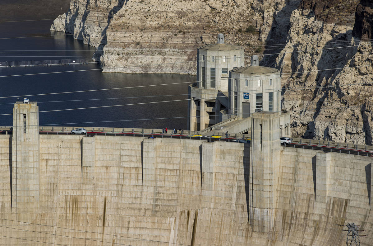 Visitors walk along the top of the Hoover Dam now open to the public after being closed for mon ...