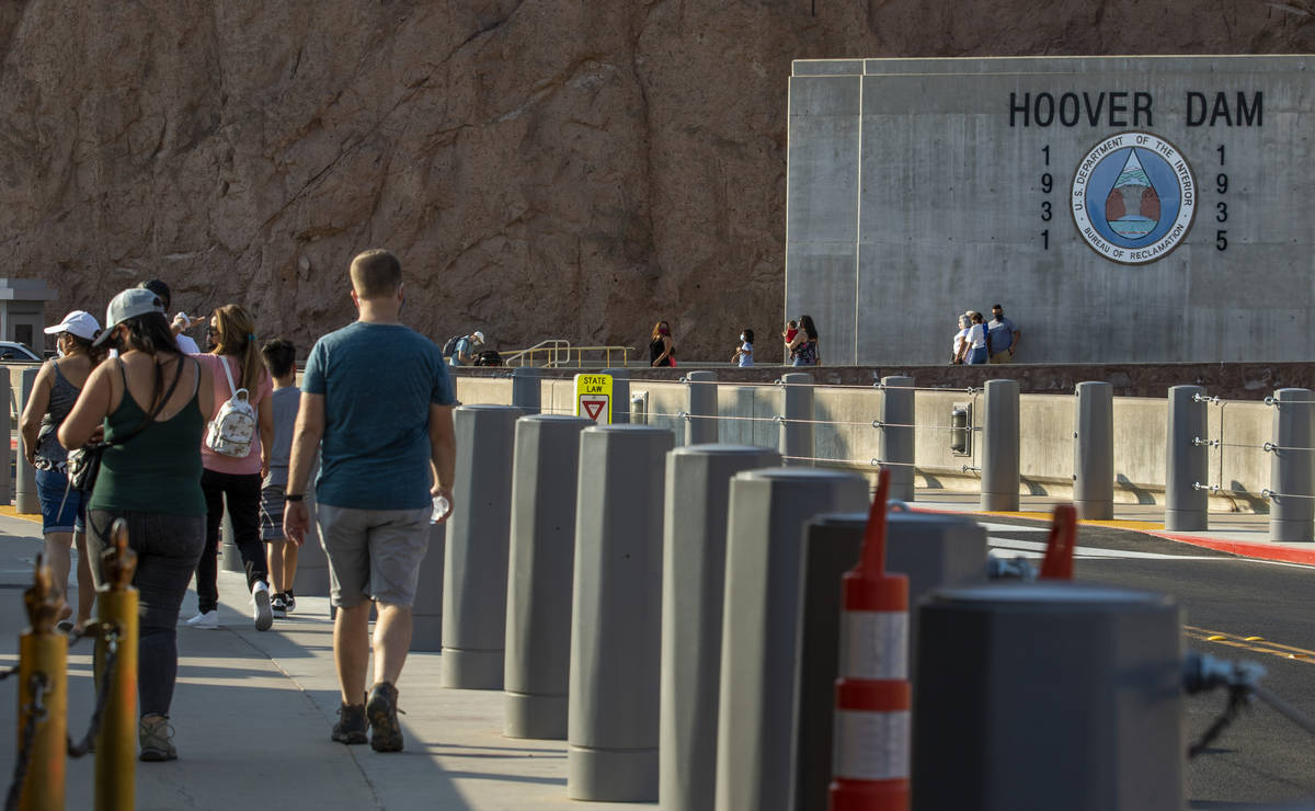 Visitors walk along the top of Hoover Dam, which reopened to the public after being closed for ...