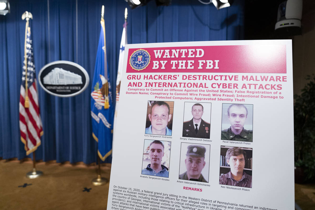 A poster showing six wanted Russian military intelligence officers is displayed before a news c ...