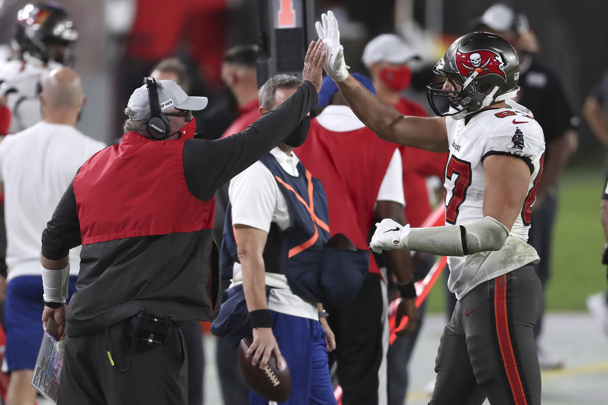 Tampa Bay Buccaneers head coach Bruce Arians high fives tight end Rob Gronkowski (87) as he lea ...