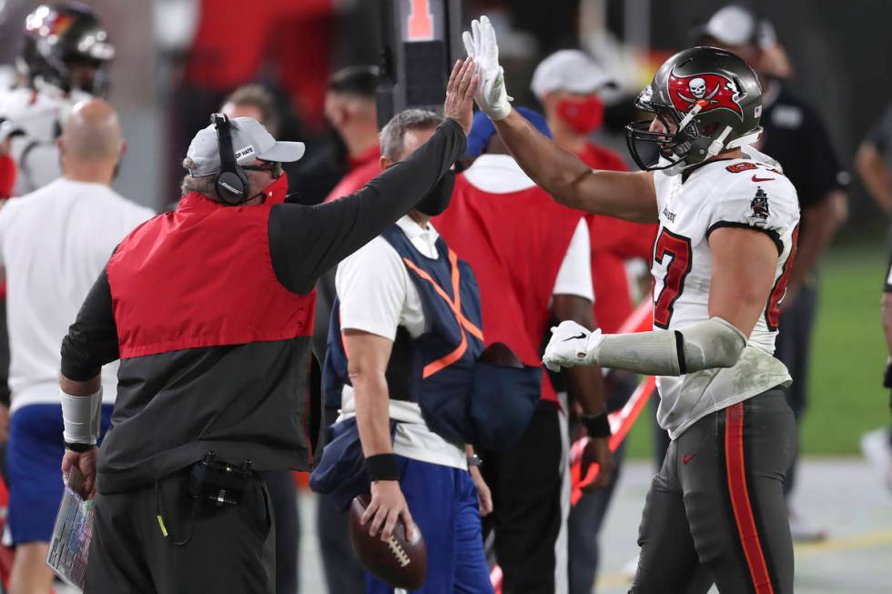 Tampa Bay Buccaneers head coach Bruce Arians high fives tight end Rob Gronkowski (87) as he lea ...