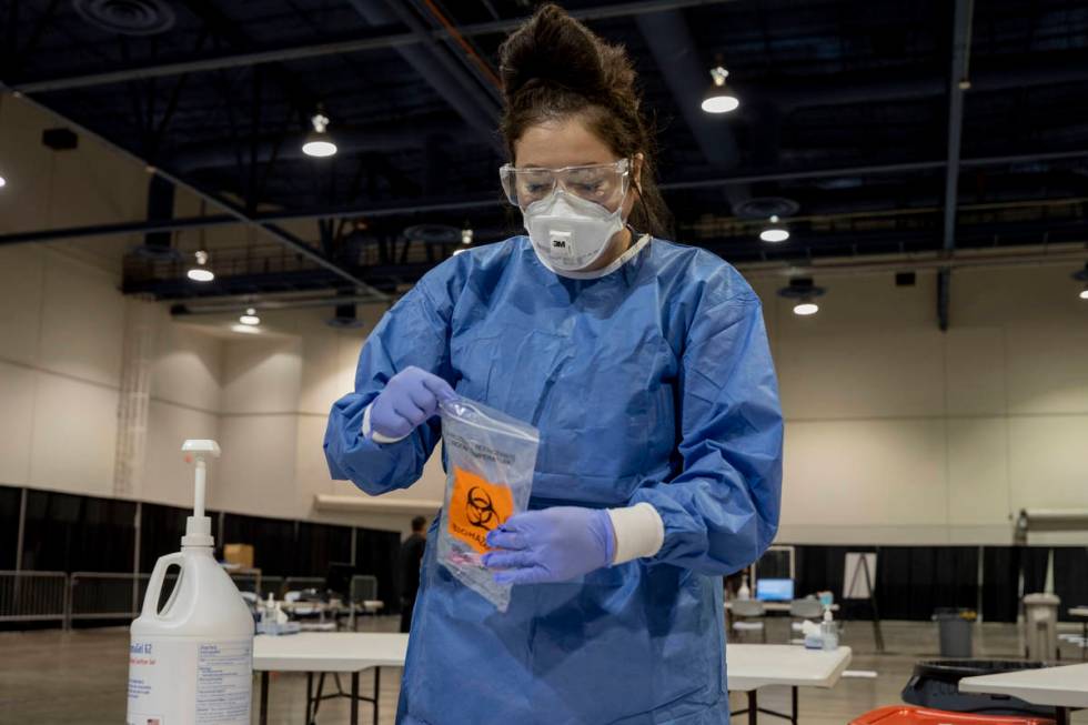In this Aug.3, 2020, file photo, UMC respiratory therapist Diana Vega seals a COVID-19 test in ...