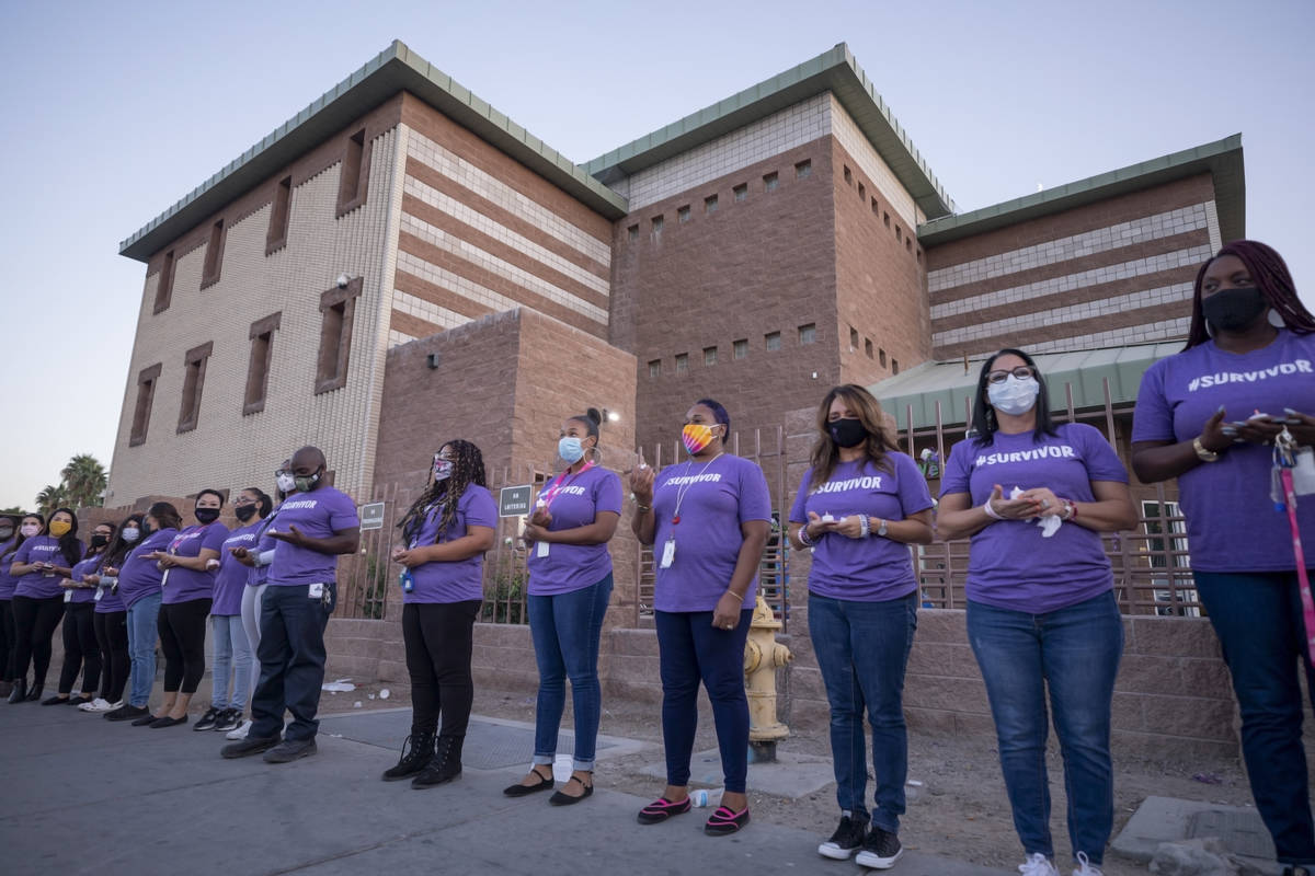 The Shade Tree staff members participate in a candlelight vigil to honor domestic violence vict ...