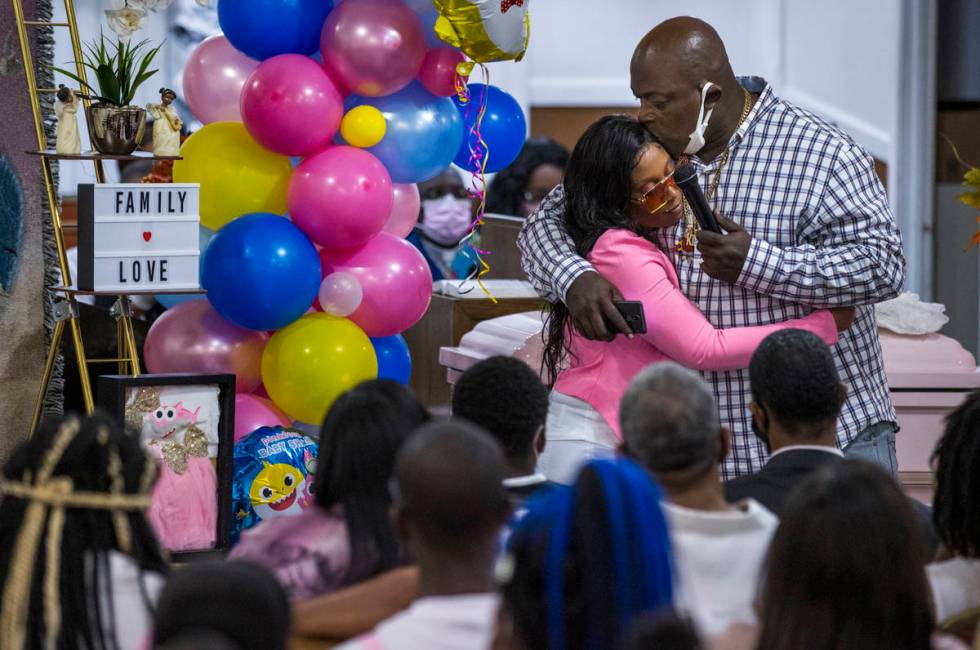 Mario Hunt, right, hugs Mariah Coleman after he recited a poem he wrote for her daughter Sayah ...