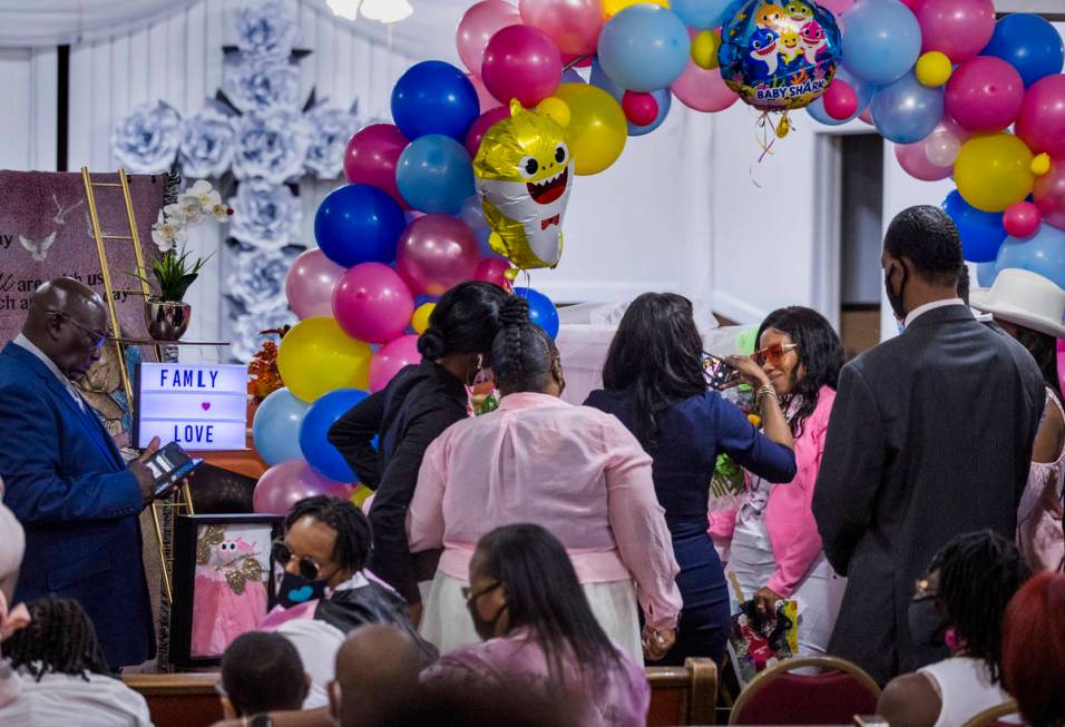 Mariah Coleman, right, has her photo taken by the casket of her daughter Sayah Deal following t ...