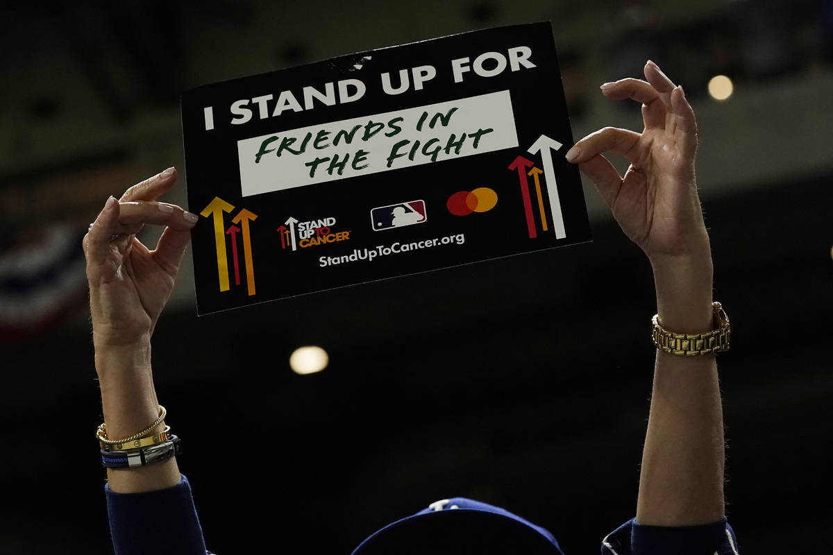 A fan participates a "Stand Up to Cancer" moment during in Game 3 of the baseball Wor ...
