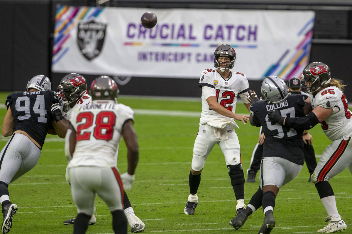 Tampa Bay Buccaneers quarterback Tom Brady (12) throws a pass to running back Leonard Fournette ...