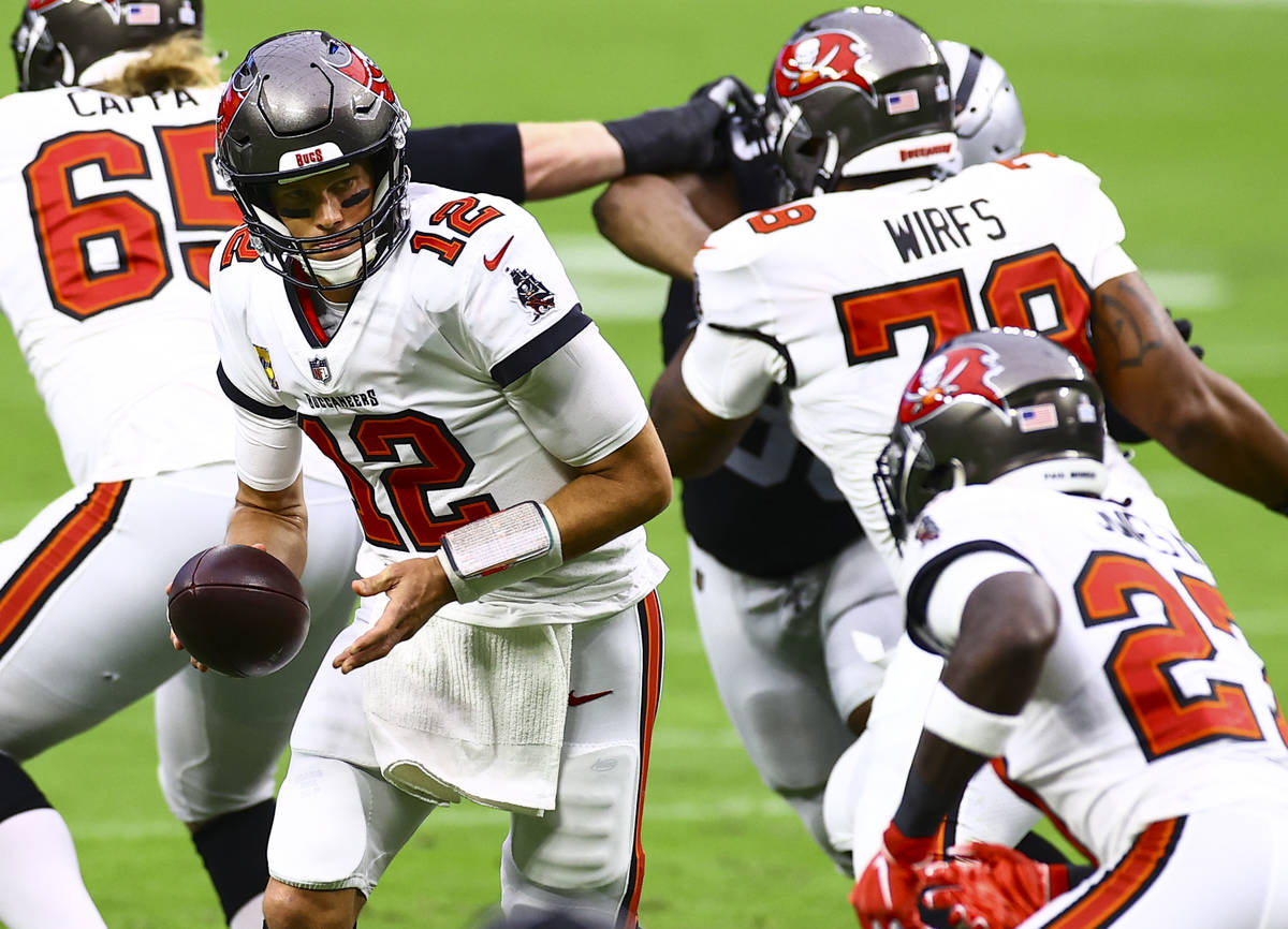 Tampa Bay Buccaneers quarterback Tom Brady (12) looks to hand off the ball to cornerback Sean M ...