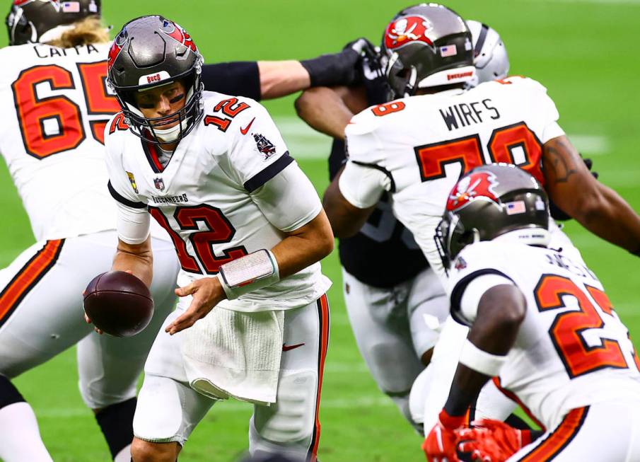 Tampa Bay Buccaneers quarterback Tom Brady (12) looks to hand off the ball to cornerback Sean M ...