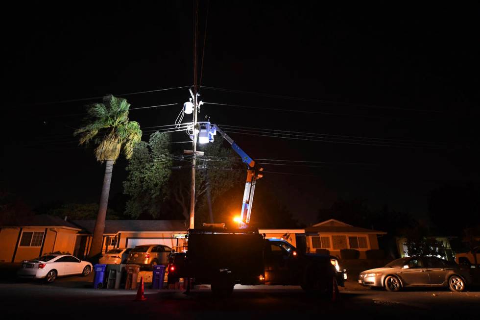 A PG&E lineman works on repairing electrical wires that were touching due to high winds on ...