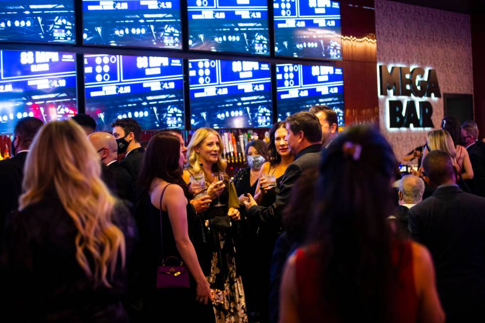 Invited guests enjoy drinks by the Mega Bar at Circa during the VIP black-tie grand opening eve ...