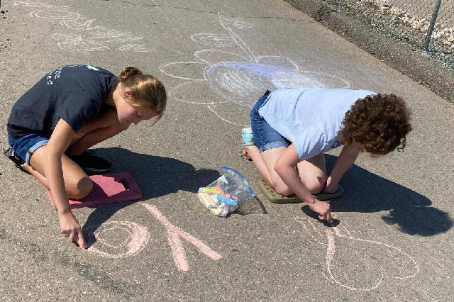 Tarkanian Middle School leadership students chalk the race route for the Candlelighters Superhe ...