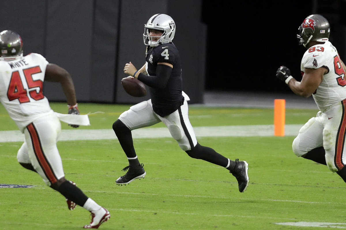 Raiders quarterback Derek Carr carries the ball during the second half of an NFL football game, ...