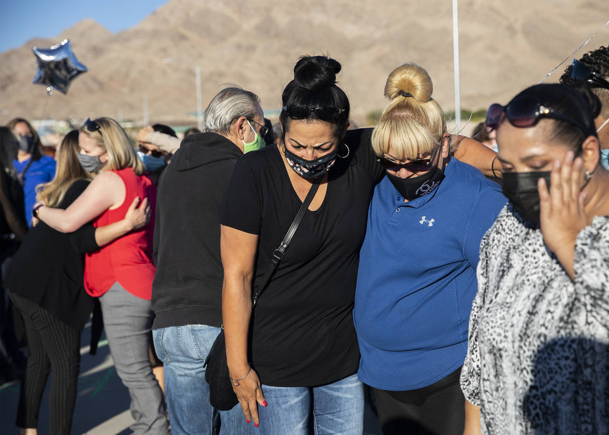 Martha Flores, left, and Laura Pi–a, right, comfort each other as they pay respects to t ...