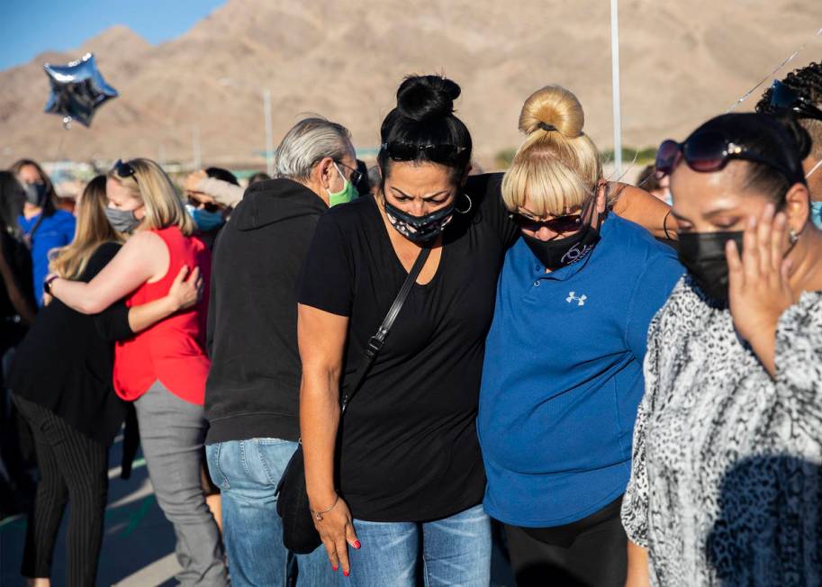 Martha Flores, left, and Laura Pi–a, right, comfort each other as they pay respects to t ...
