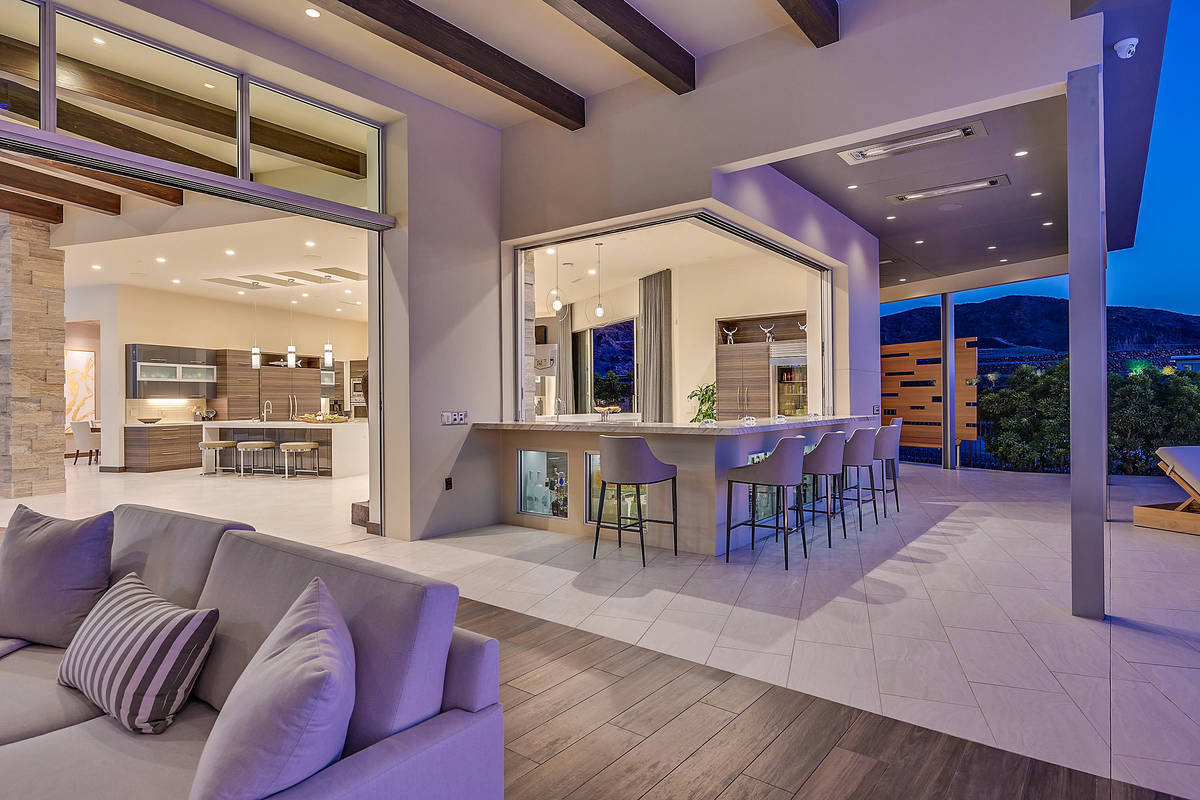 The indoor/outdoor bar extends to the patio that has an outdoor kitchen, pool and spa and seati ...