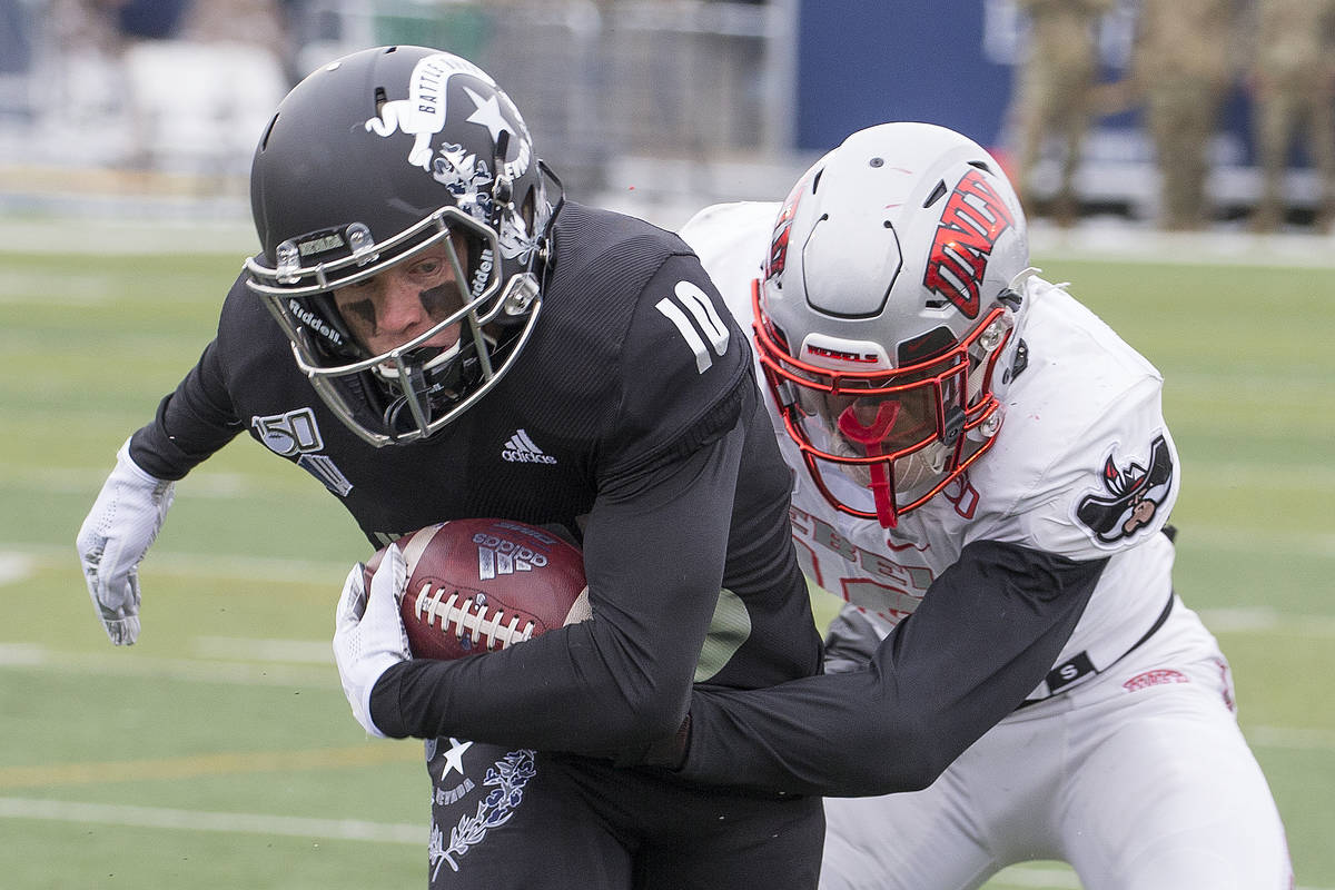 UNR wide receiver Ben Putman (10) is grabbed by UNLV linebacker Javin White (16) in the first h ...