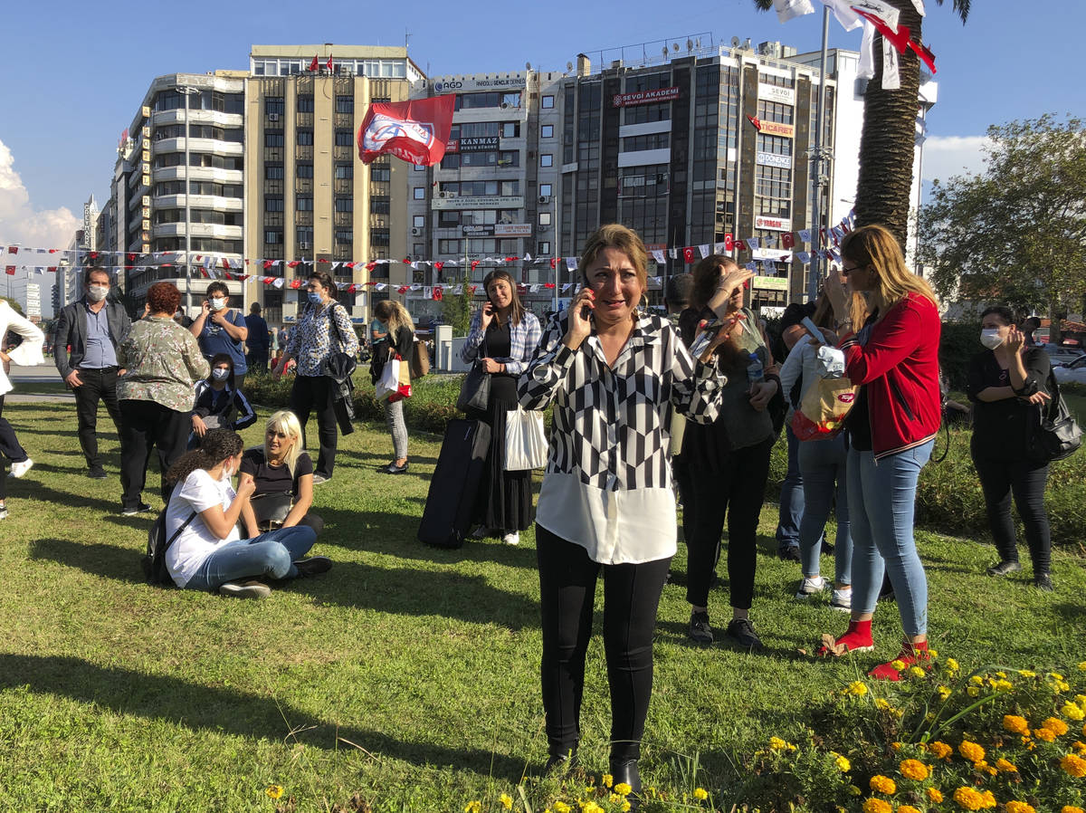People stand outside their homes in Izmir, Turkey, Friday, Oct. 30, 2020, after a strong earthq ...