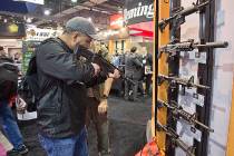Stuart Konicar of Scottsdale, Ariz., looks down the sight of a Remington Adaptive Combat Rifle ...
