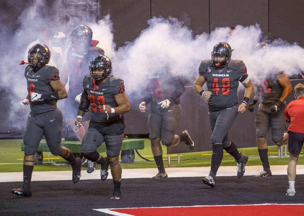 UNLV Rebels players take the field to face the Nevada Wolf Pack before the first half of their ...