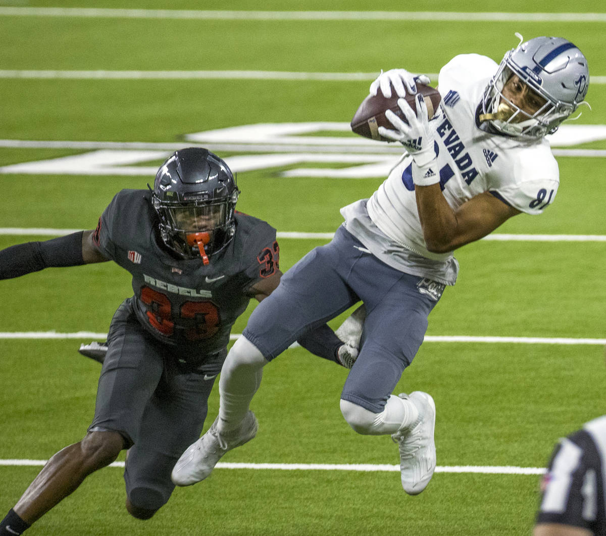 Nevada Wolf Pack wide receiver Charles Ross (81, right) elevates to make a catch over UNLV Rebe ...